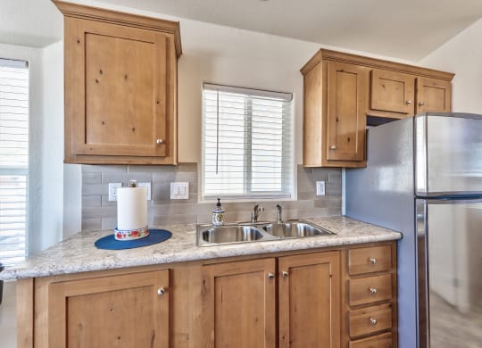 a kitchen with wooden cabinets and a stainless steel refrigerator