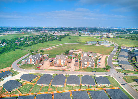 A bird's eye view of a residential area with houses and solar panels.