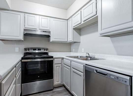 A kitchen with white cabinets and stainless steel appliances.