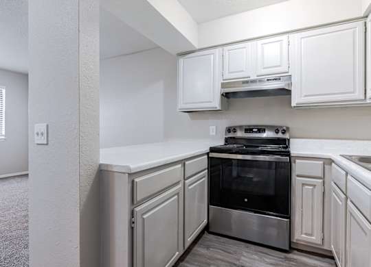 A kitchen with white cabinets and a stainless steel oven.
