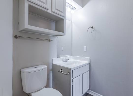A white toilet and sink in a small bathroom.