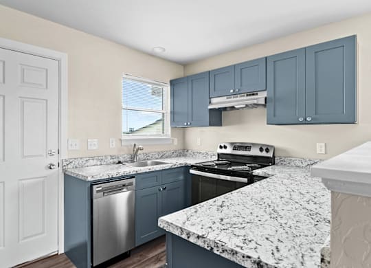 A kitchen with a granite countertop and blue cabinets.