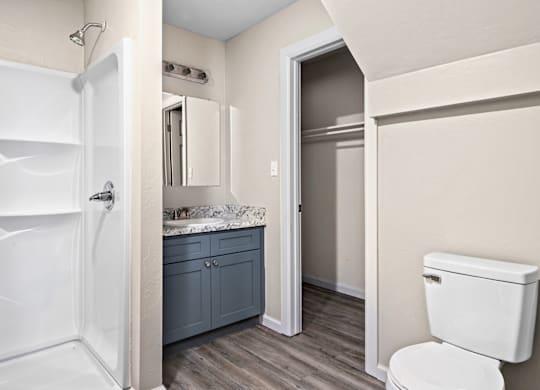 A white toilet sits next to a white bathtub in a bathroom.