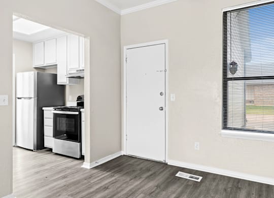 A kitchen with a white fridge and stove with a white door.
