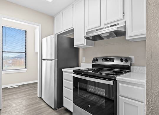 A kitchen with white cabinets and a black stove top oven.