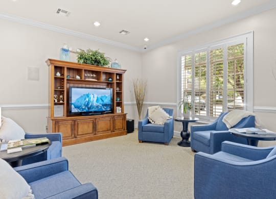 a living room with blue chairs and a television