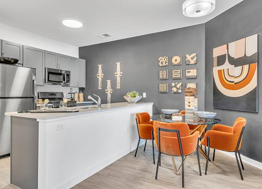 A modern kitchen with a dining table set for four.
