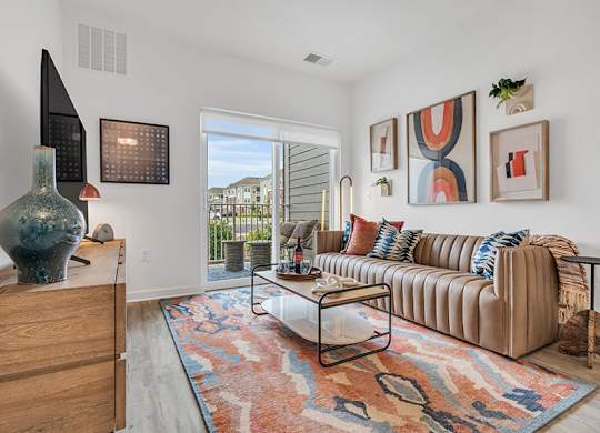 A living room with a couch, a table, and a vase.