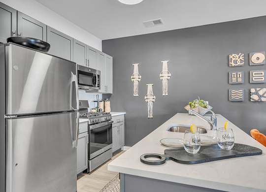 A modern kitchen with a stainless steel refrigerator and a white countertop.