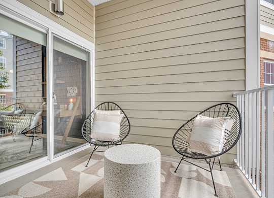 A patio with two chairs and a table.