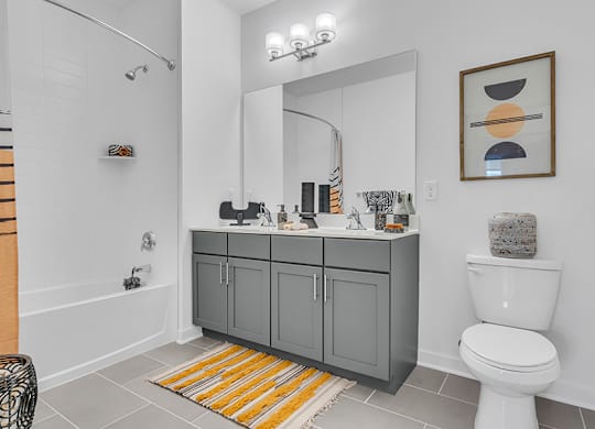 A bathroom with a white toilet and a grey cabinet.
