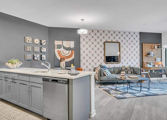 A modern kitchen with a grey cabinetry and a grey and white patterned wallpaper.