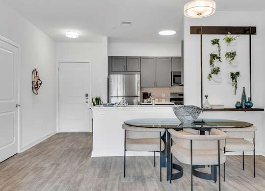 A modern kitchen with a dining table and chairs.