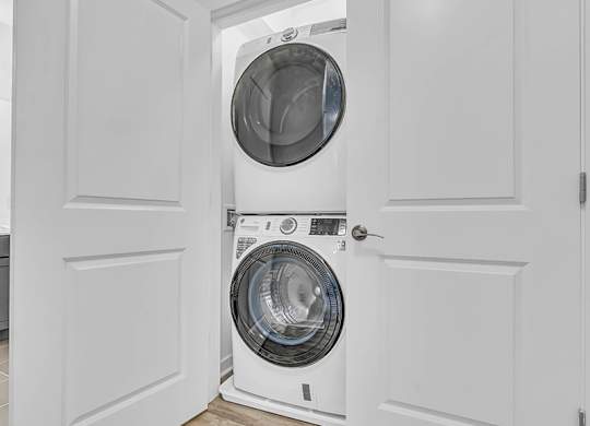 A white washing machine is in a white door.