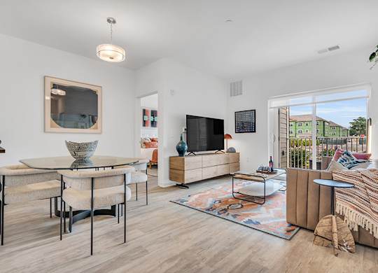 A modern living room with a large flat screen TV and a glass coffee table.