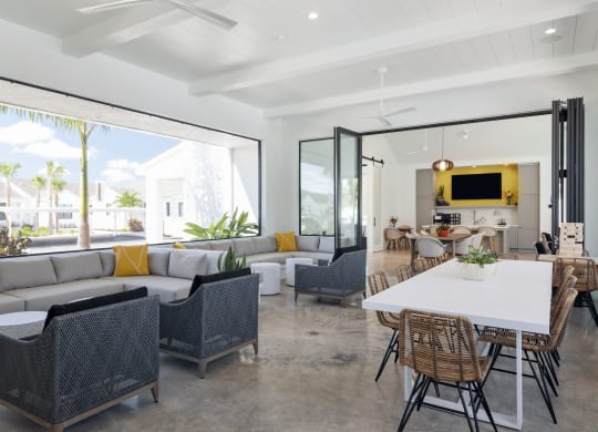 Open concept resident space with a white dining table and rattan chairs