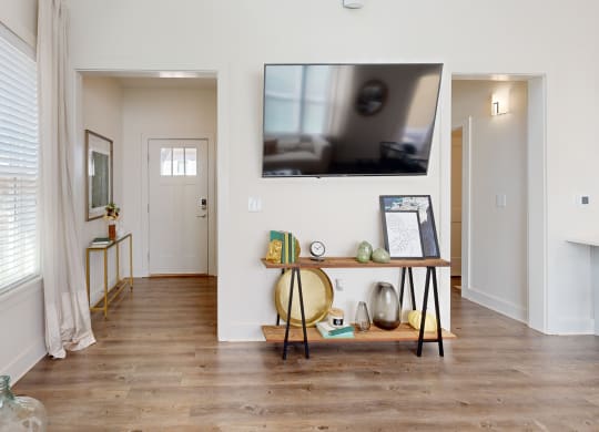 a living room with a tv on the wall and a wooden floor