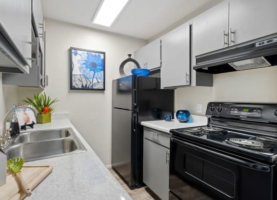 Kitchen with stainless steel appliances and a stove and refrigerator at Verde Apartments in Tucson, 85719