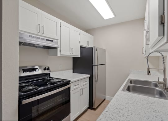 Kitchen with white cabinets and a black stove and refrigerator at Verde Apartments in Tucson, 85719