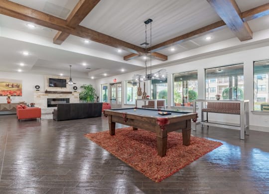 Community Clubroom with Large Windows and a Pool Table and Benches  at Legacy Brooks, San Antonio