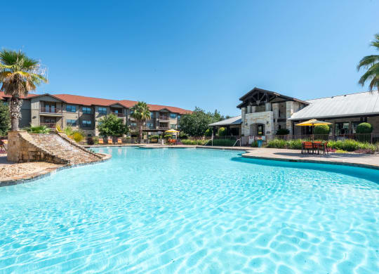 Swimming Pool with Leasing Office in Background  at Legacy Brooks, San Antonio, TX, 78223