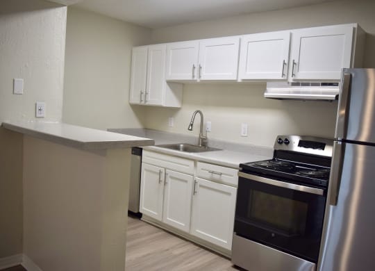 a kitchen with stainless steel appliances and white cabinets