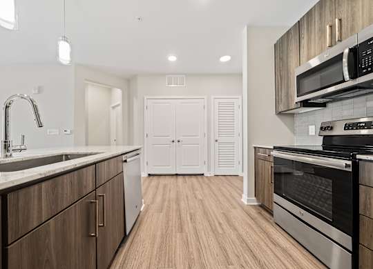 A modern kitchen with wooden cabinets and stainless steel appliances.