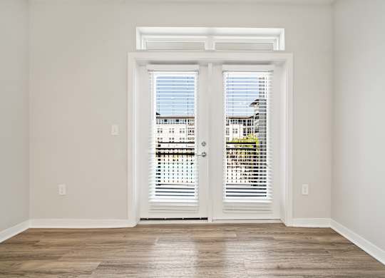 A room with a view of a building through the window.