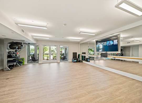 A spacious room with a large screen and a wooden floor.