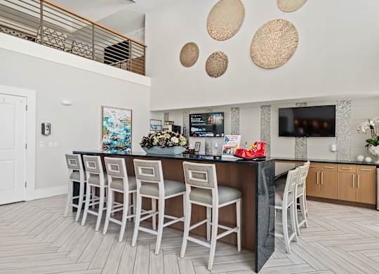 A modern kitchen with a bar area and a dining table.