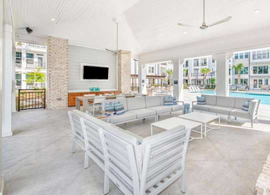 A large white room with a pool table and a television.