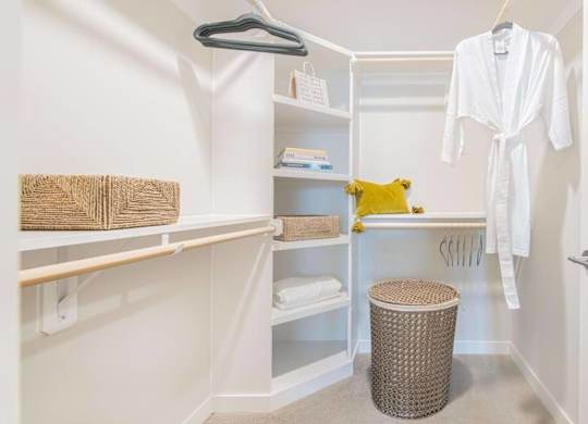 A white bathroom with a white robe hanging up.