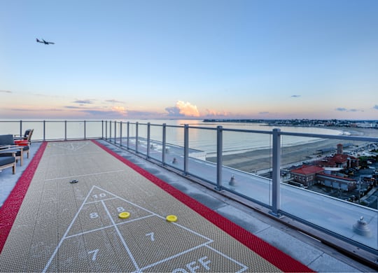 A shuffleboard court on a balcony with a view of the city.