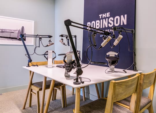 A studio setup with a microphone and headphones on a table.