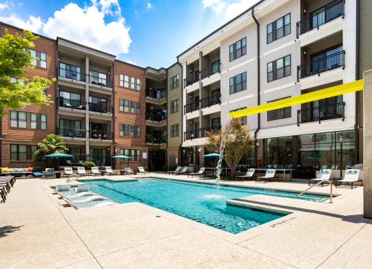 a swimming pool in front of an apartment building