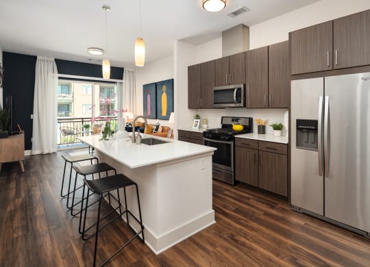 a kitchen with a large island and stainless steel appliances