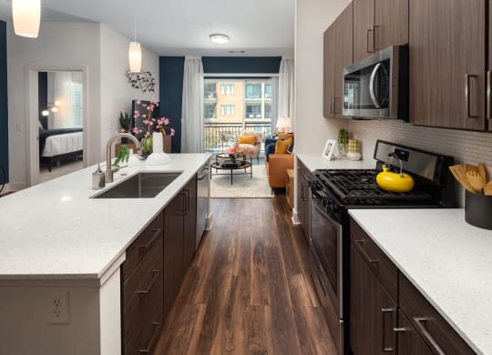 a kitchen with white counter tops and wooden floors
