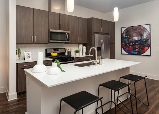 a kitchen with a large island with three stools
