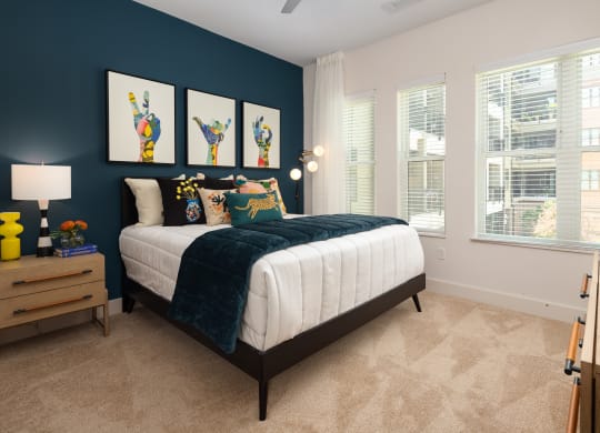 a bedroom with a bed and three windows