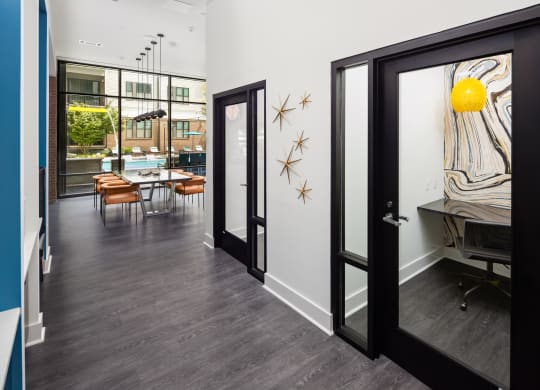 a hallway with a door open to a dining room with a table and chairs