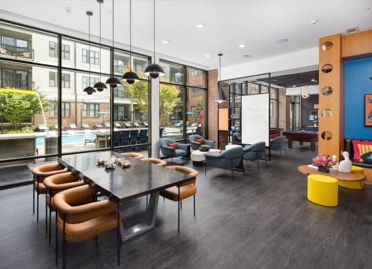 a communal area with a table and chairs and a large window