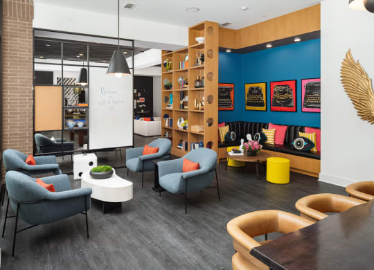 a lounge area with chairs and tables and a whiteboard