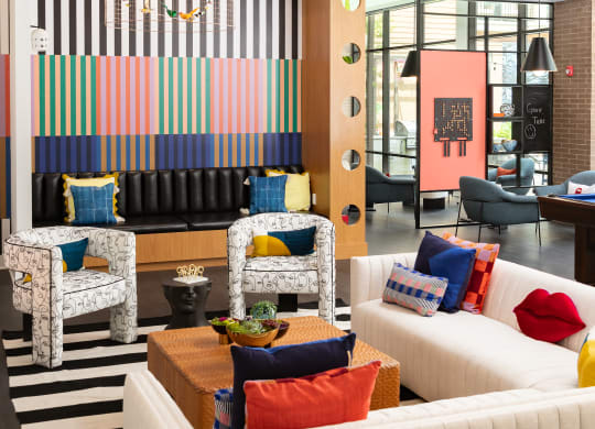 a living room with couches and chairs and a striped wallpaper
