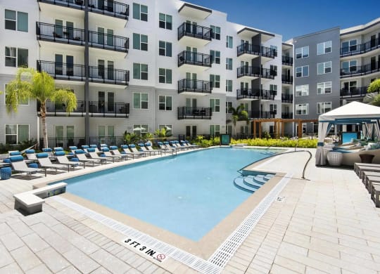 Sunny Pool Area with Comfortable Seating and Poolside Cabanas