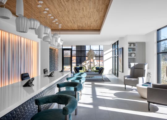 a living room with green chairs and a long white counter