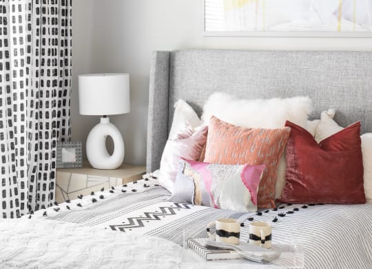 a bedroom with a bed and pillows and a painting on the wall