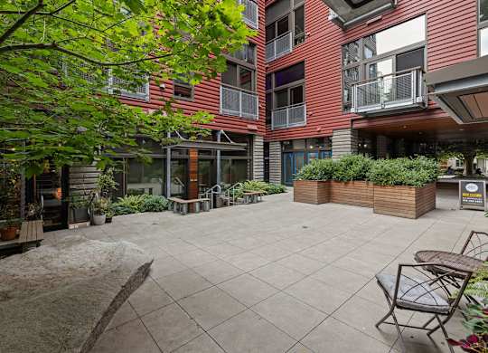 A courtyard with a table and chairs surrounded by buildings.
