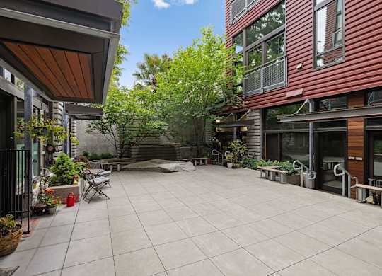 A patio with a table and chairs is surrounded by buildings.