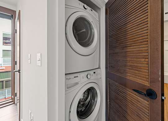 A modern washing machine is built into a wooden door.