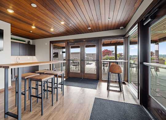A modern kitchen with a bar area and sliding glass doors.